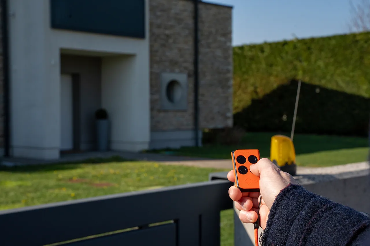 radiocomando universale mano che preme bottone radiocomando apre cancello