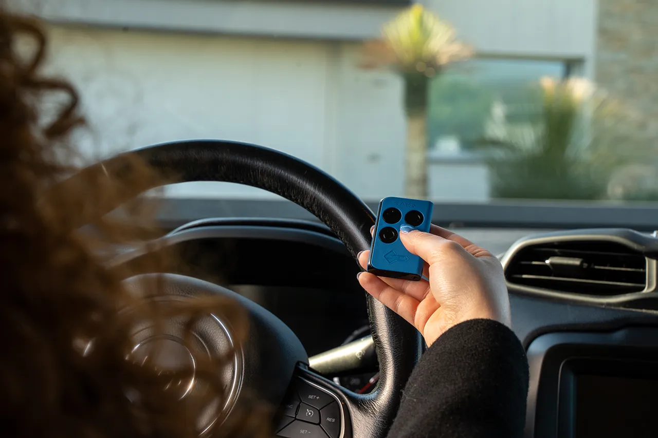 radiocomando universale donna che apre il garage dall'interno dell'auto